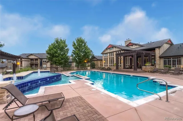 a view of a house with pool and chairs