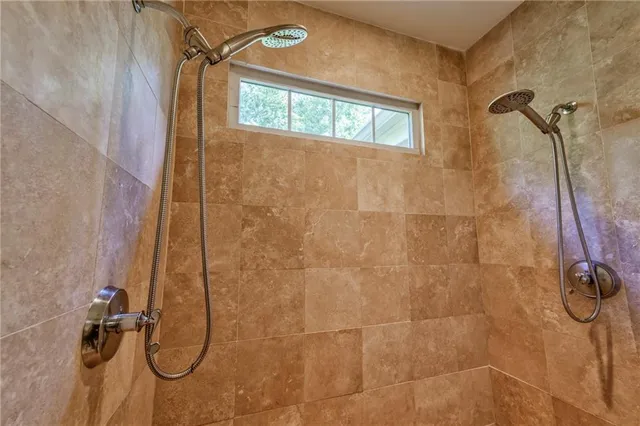 a view of a patio with a dining table and chairs under an umbrella with large trees