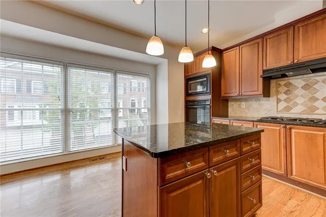 a view of a kitchen with wooden floor and electronic appliances