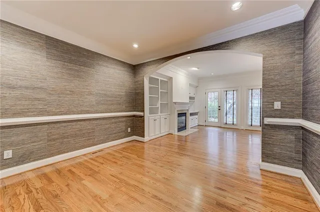 a view of a livingroom with a fireplace wooden floor and chandelier