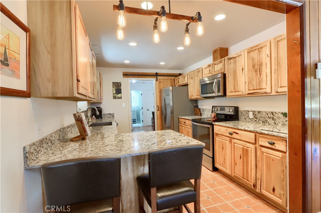 5641B Darrah Road Mariposa, CA 95338 - Photo 2 of 55 a kitchen with kitchen island granite countertop a table chairs sink and cabinets