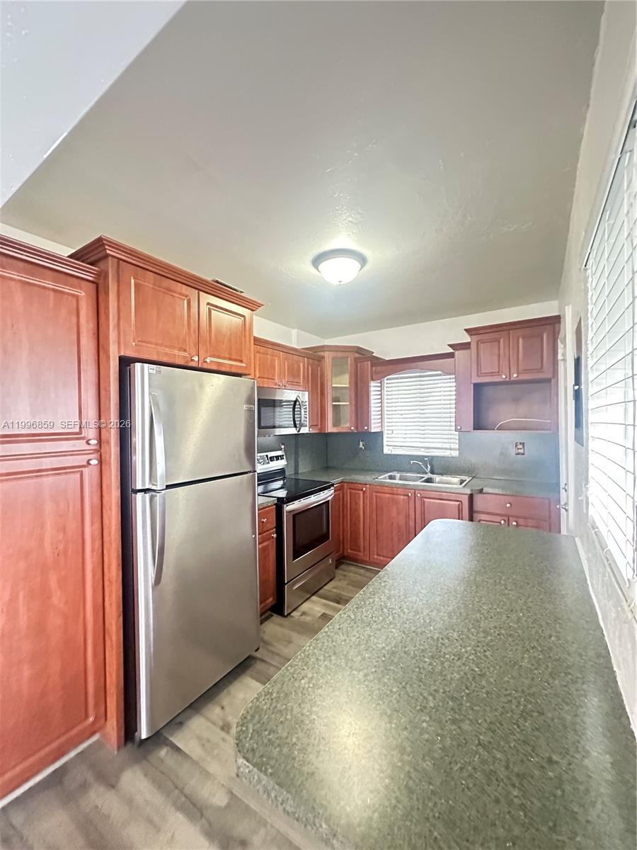 4232 Northwest 2nd Terrace, Unit A Miami, FL 33126 - Photo 5 of 11 a kitchen with stainless steel appliances a refrigerator and a window