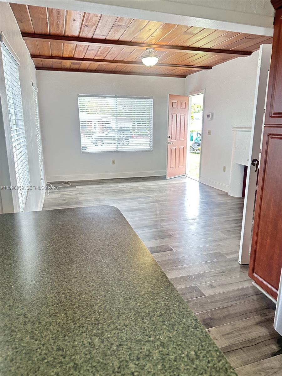 4232 Northwest 2nd Terrace, Unit A Miami, FL 33126 - Photo 6 of 11 a view of an empty room with wooden floor and a window