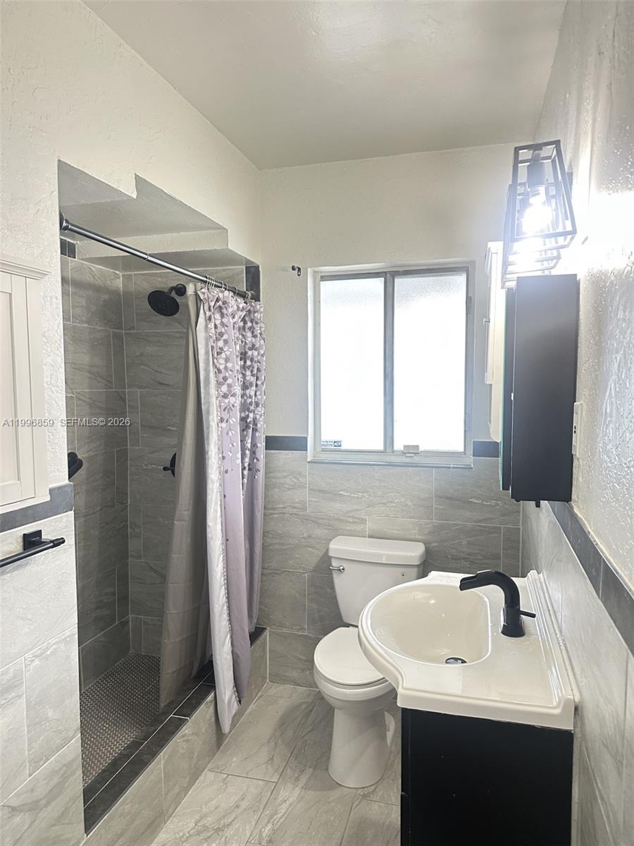 4232 Northwest 2nd Terrace, Unit A Miami, FL 33126 - Photo 7 of 11 a bathroom with a sink a toilet and shower