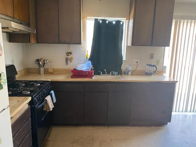 a kitchen with a sink a stove and cabinets