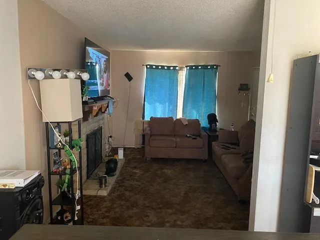 a living room with furniture a flat screen tv and a window