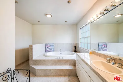 a en suite bathroom with a tub sink and mirror