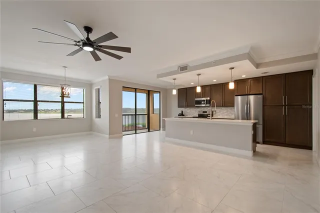 a view of large kitchen with a sink and refrigerator
