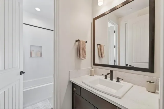 a bathroom with a granite countertop sink vanity and mirror