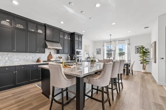 a kitchen with a dining table chairs and wooden floor