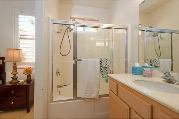 a bathroom with a shower sink and mirror