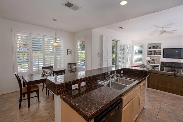 a kitchen with granite countertop a sink a counter space appliances and furniture