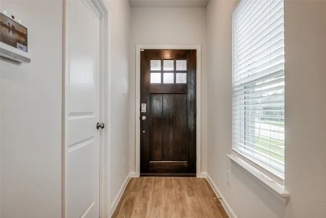 a view of a hallway with wooden floor and a window