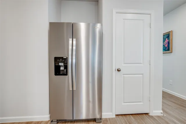 a view of a hallway with wooden floor and closet