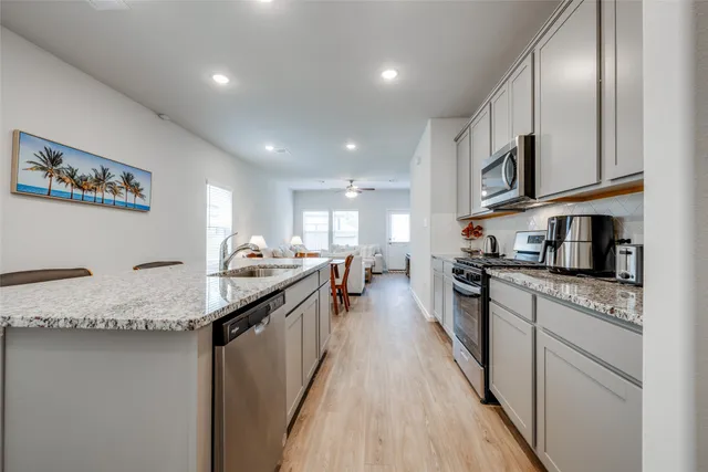 a kitchen with stainless steel appliances granite countertop counter space a sink and cabinets