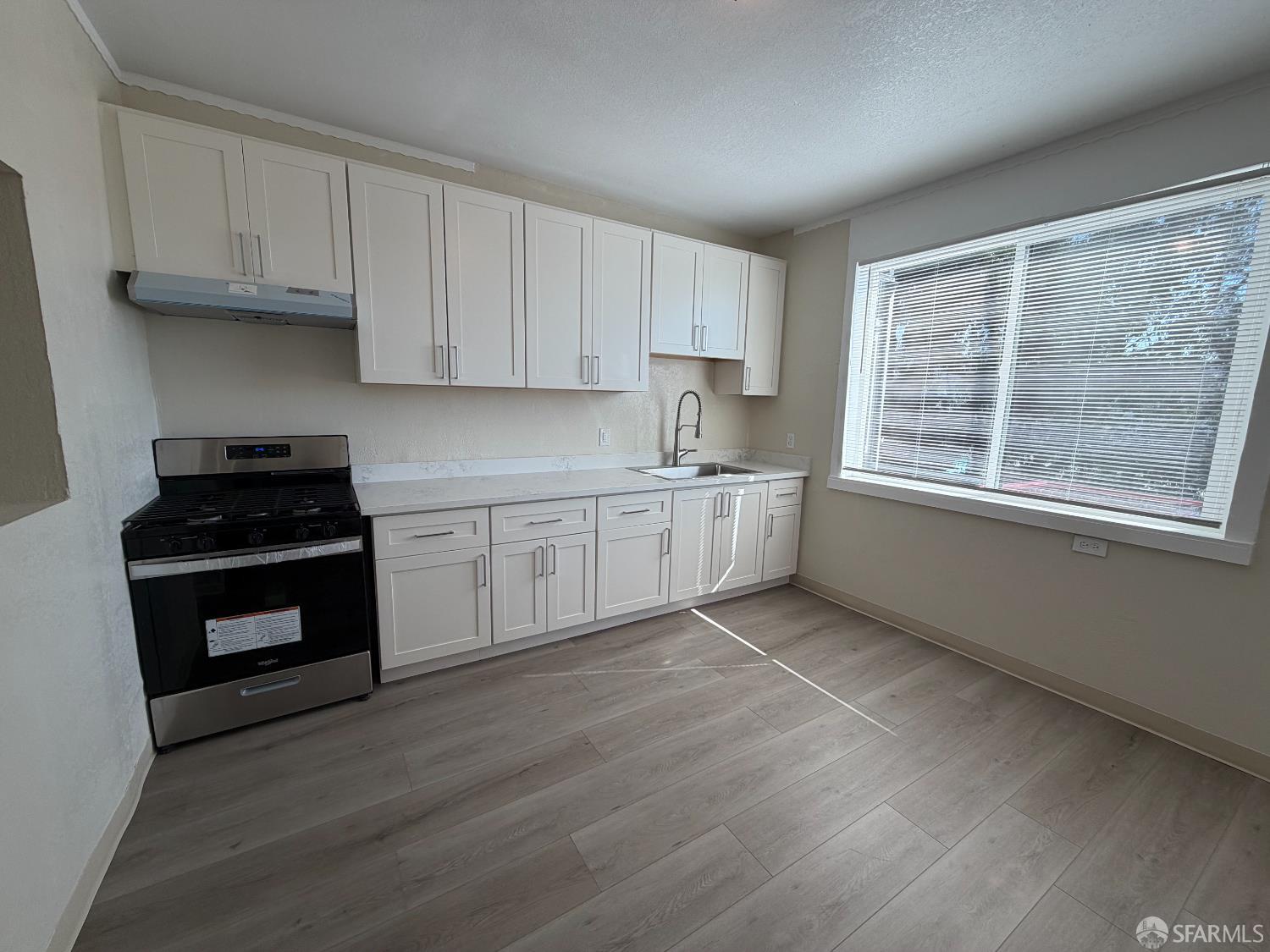 65 Minerva Street San Francisco, CA 94112 - Photo 6 of 24 a kitchen with stainless steel appliances granite countertop a stove a sink and white cabinets