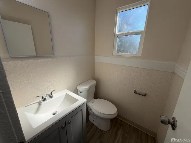 a bathroom with a sink mirror and toilet
