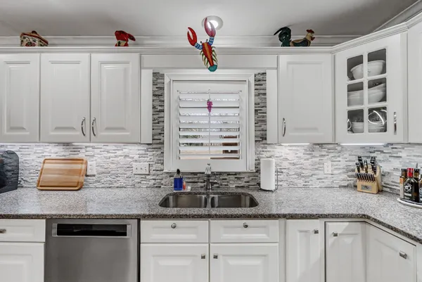 a kitchen with stainless steel appliances granite countertop a sink a stove and cabinets