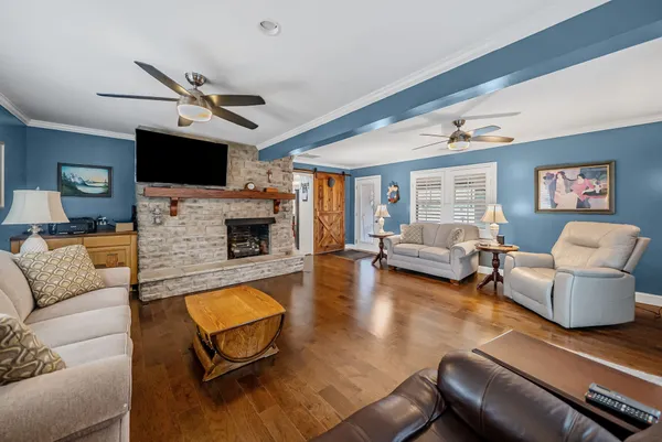 a living room with furniture a flat screen tv and a fireplace