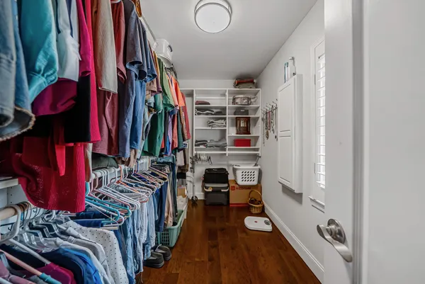 a view of walk in closet with clothes and shoes