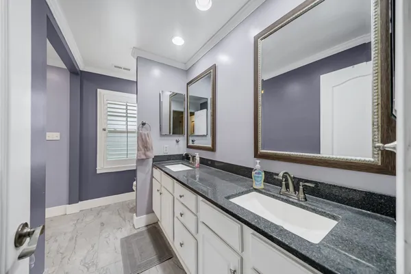 a bathroom with a sink double vanity granite and a mirror