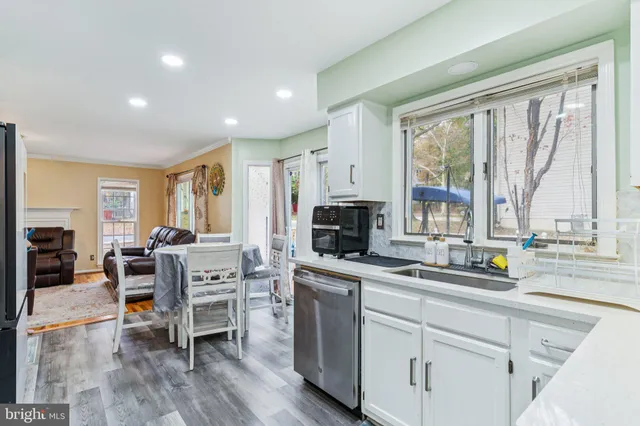 a kitchen with white cabinets and sink