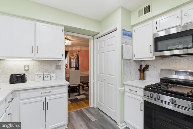 a kitchen with stainless steel appliances white cabinets sink and a stove