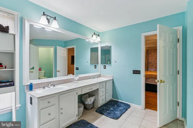 a spacious bathroom with a double vanity sink a mirror and a shower