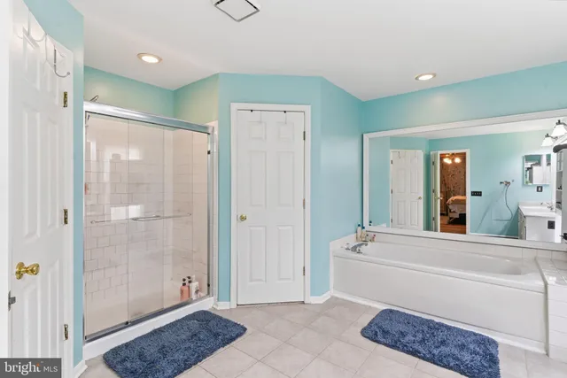 a bathroom with a shower a sink a window and a mirror