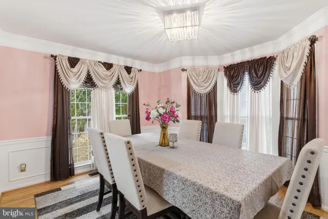 a dining room with wooden floor and chandelier