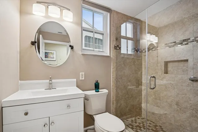 a bathroom with a toilet a sink and mirror