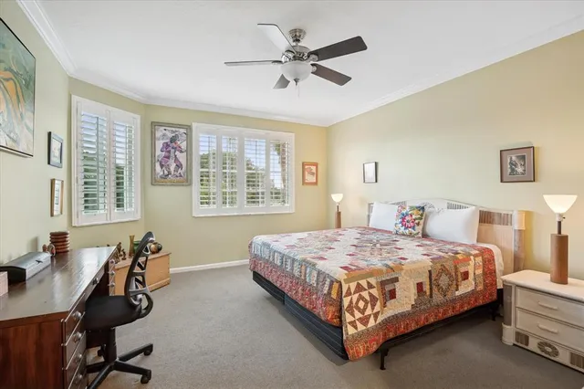 a bedroom with a bed a desk and chair next to a window