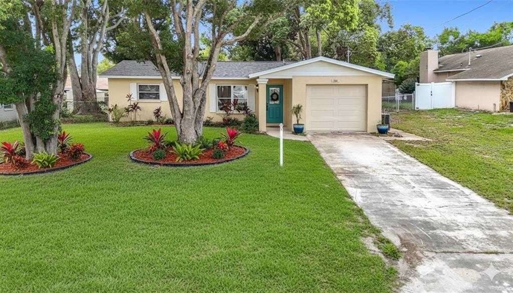 a front view of a house with a yard and trees