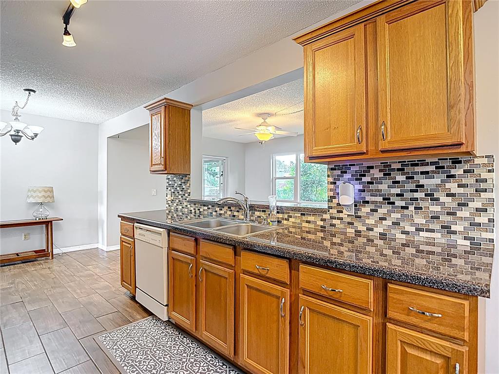 7318 Tranquil Drive Spring Hill, FL 34606 - Photo 12 of 38 a kitchen with stainless steel appliances a sink and cabinets