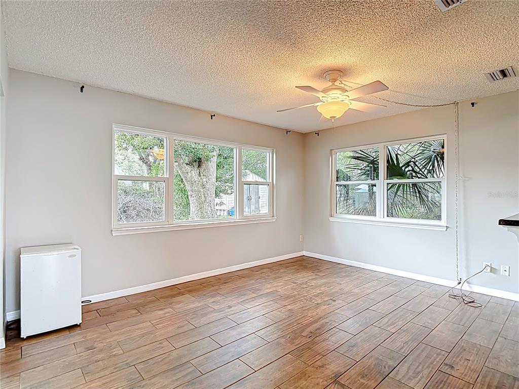 7318 Tranquil Drive Spring Hill, FL 34606 - Photo 14 of 31 a view of an empty room with a window and wooden floor