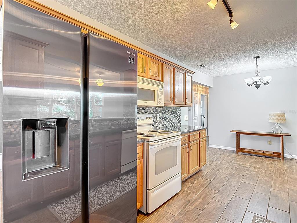7318 Tranquil Drive Spring Hill, FL 34606 - Photo 16 of 38 a kitchen with stainless steel appliances granite countertop a refrigerator and a stove
