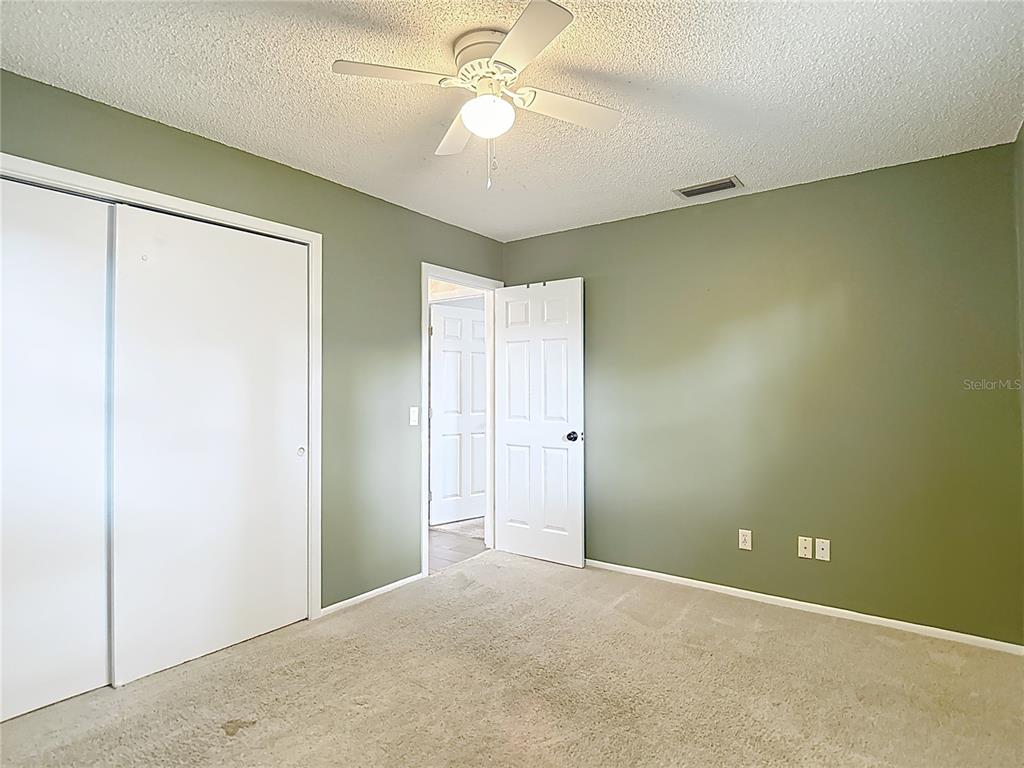 7318 Tranquil Drive Spring Hill, FL 34606 - Photo 16 of 31 a view of a room with a ceiling fan and a window