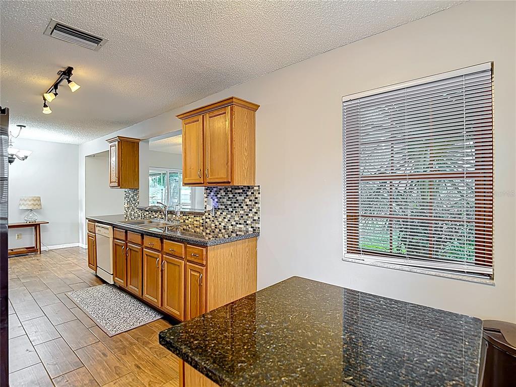 7318 Tranquil Drive Spring Hill, FL 34606 - Photo 18 of 38 a kitchen with stainless steel appliances granite countertop a stove a sink and a refrigerator