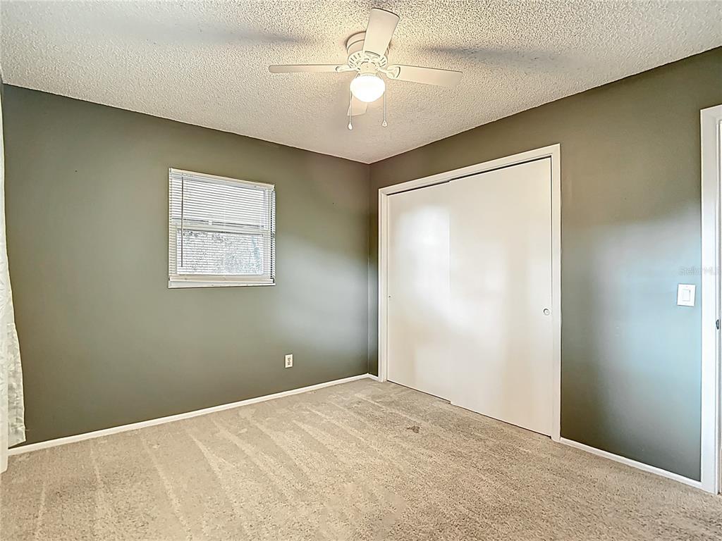 7318 Tranquil Drive Spring Hill, FL 34606 - Photo 18 of 31 a view of a big room with windows and ceiling fan