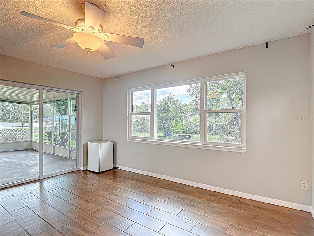 7318 Tranquil Drive Spring Hill, FL 34606 - Photo 19 of 38 a view of an empty room with wooden floor and a window
