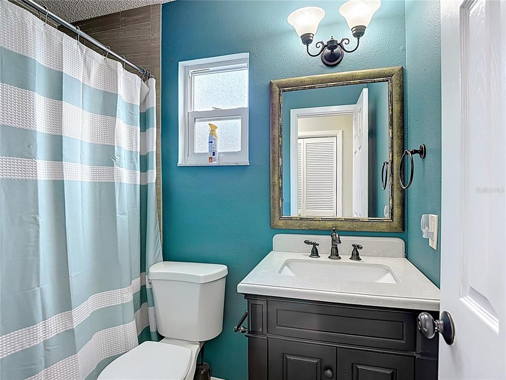 7318 Tranquil Drive Spring Hill, FL 34606 - Photo 24 of 31 a bathroom with a sink a toilet and mirror