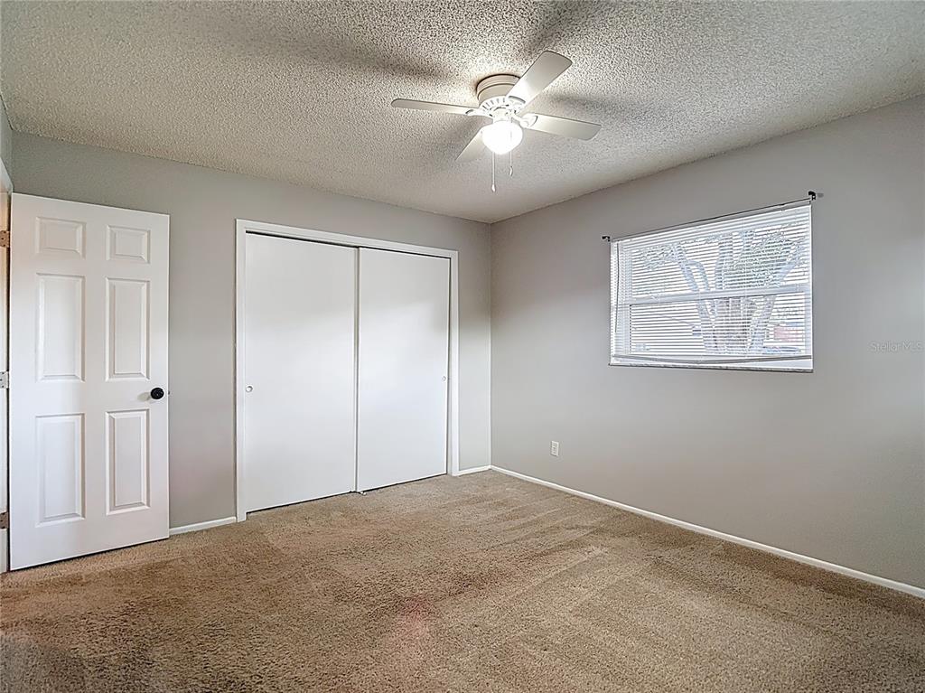 7318 Tranquil Drive Spring Hill, FL 34606 - Photo 27 of 38 an empty room with windows and fan
