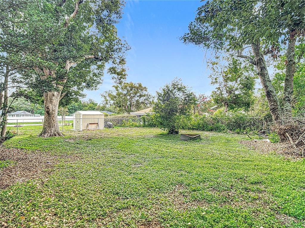 7318 Tranquil Drive Spring Hill, FL 34606 - Photo 35 of 38 a view of a big yard with a house and large trees