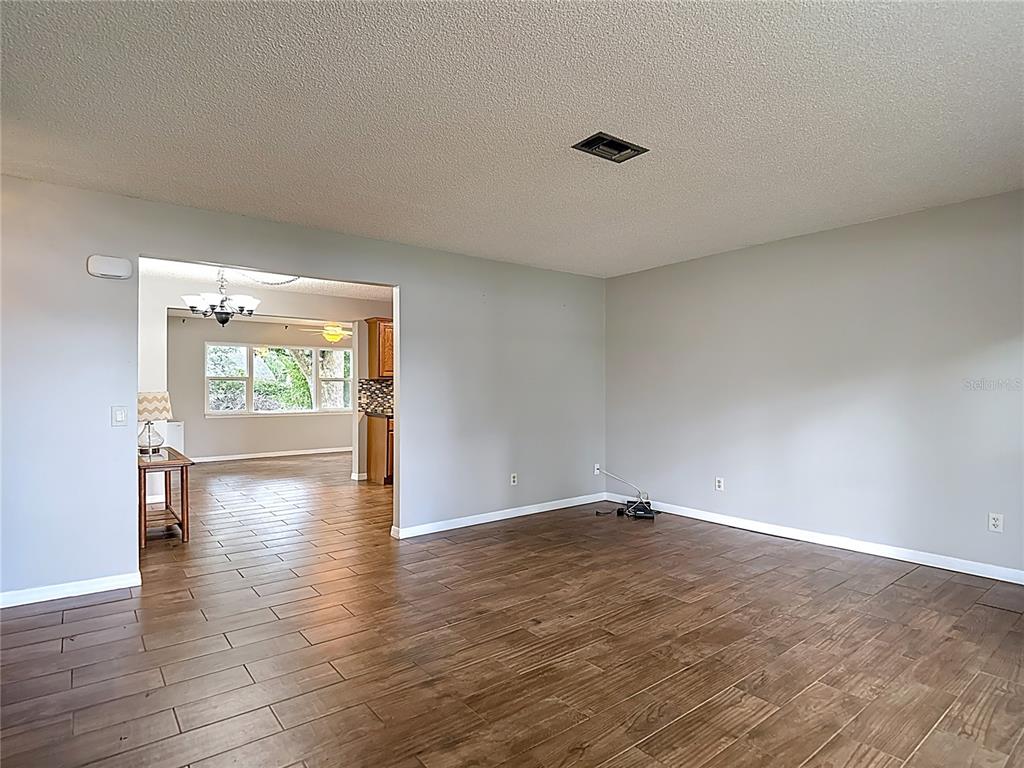 7318 Tranquil Drive Spring Hill, FL 34606 - Photo 5 of 38 a view of an empty room with wooden floor and a window