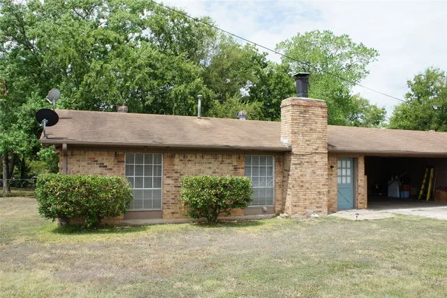 a front view of a house with a garden and plants