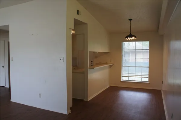an empty room with windows and ceiling fan