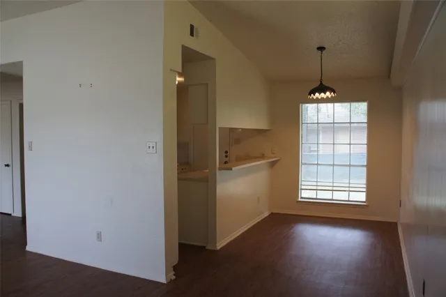 an empty room with windows and ceiling fan