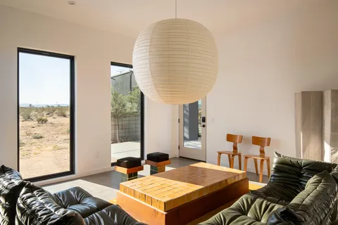 a living room with furniture a large window and a potted plant