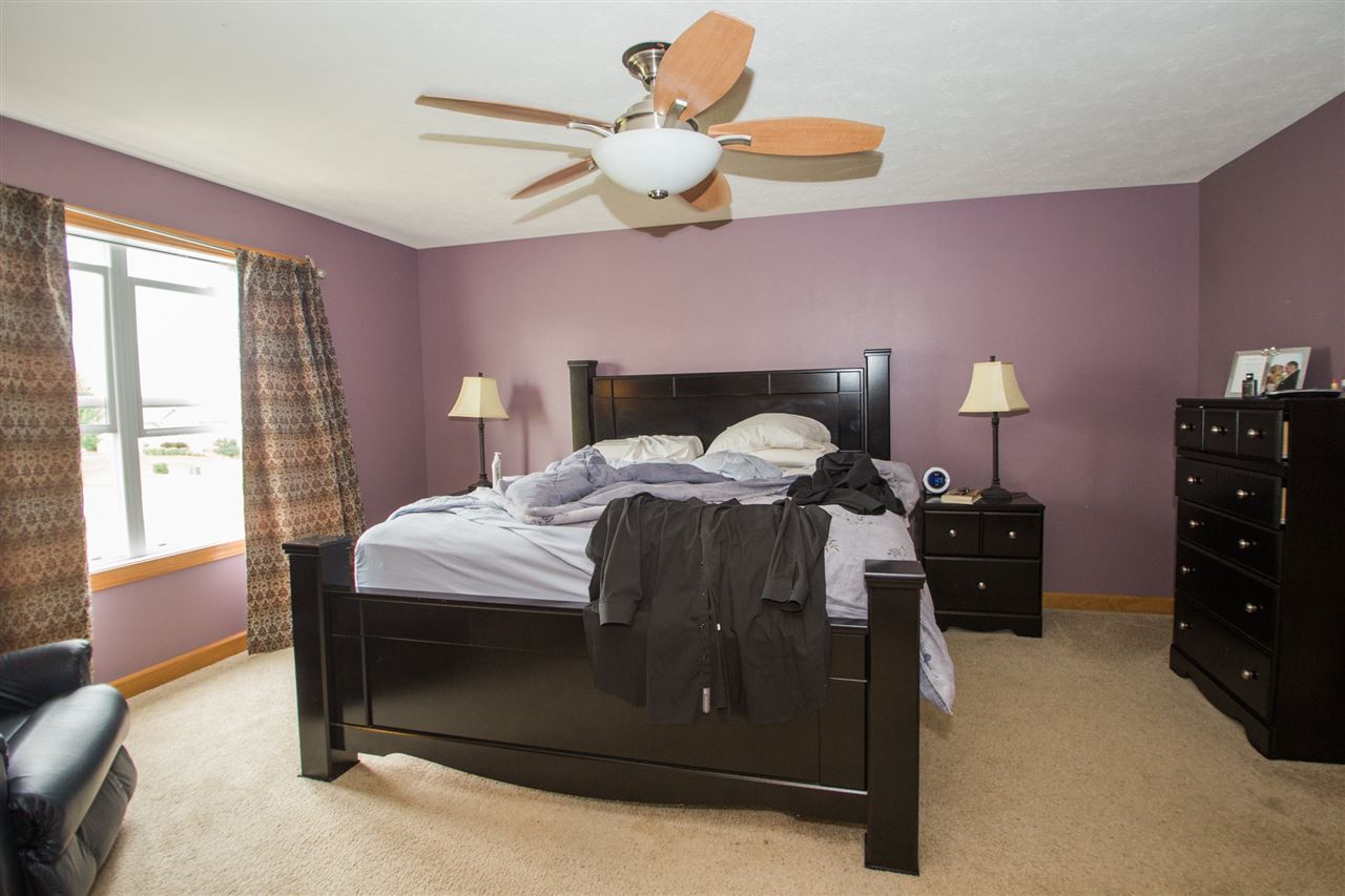 645 Merrion Road Roscoe, IL 61073 - Photo 14 of 24 a bedroom with a bed and a chandelier