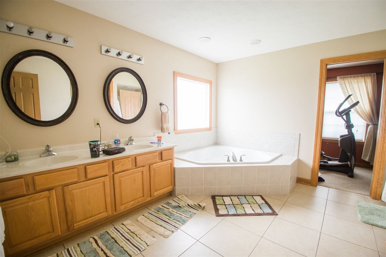 645 Merrion Road Roscoe, IL 61073 - Photo 15 of 24 a bathroom with a tub sink and mirror